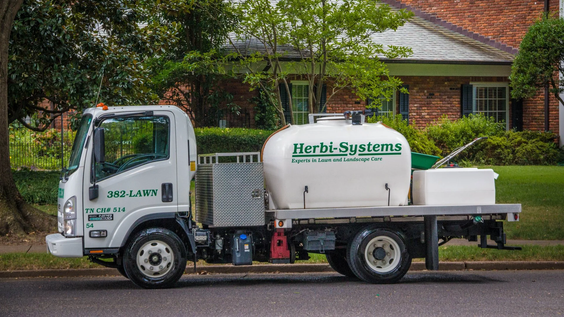 Herbi-Systems lawn care truck at property.